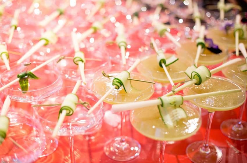Yellow and pink cocktails with cucumber sticks
