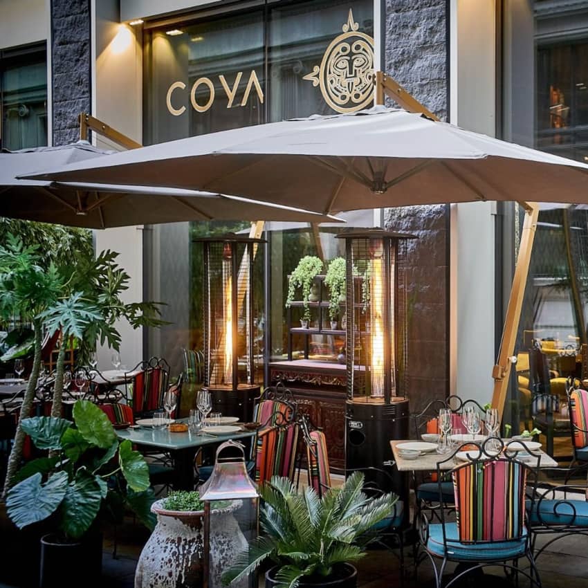 Coya London terrace with colorful chairs and heaters