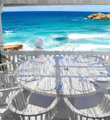white table half round chairs sea view