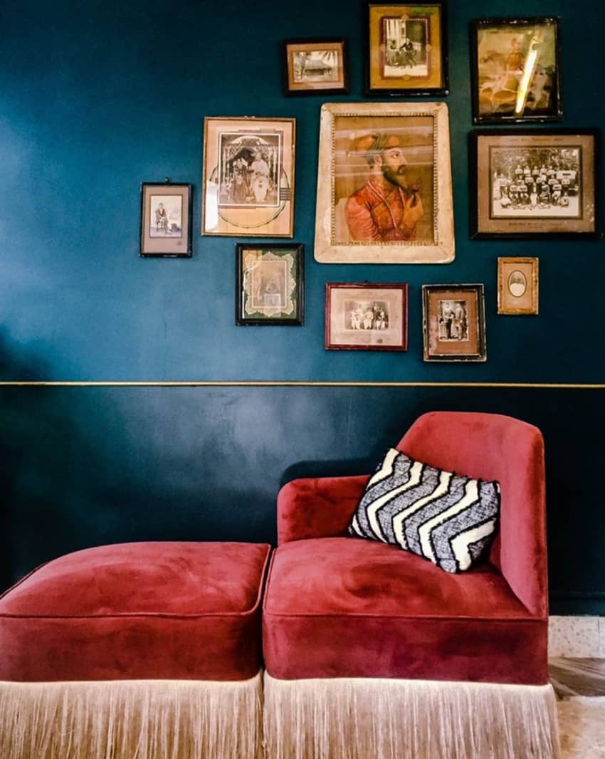 old framed portraits blue wall red couch