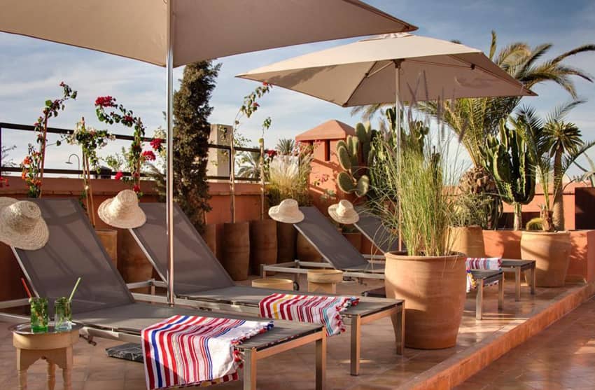 rooftop loungers straw hat parasols clay potted plants