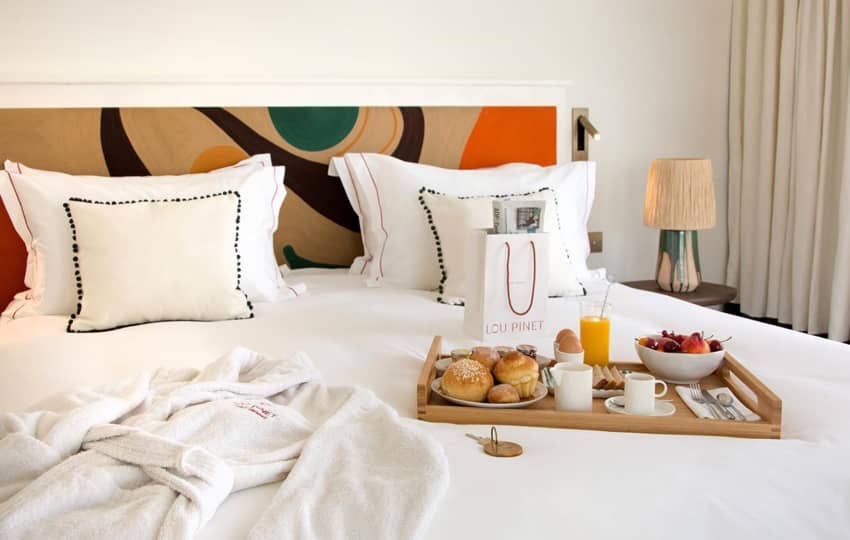 breakfast tray pastries fruits large bed bathrobe