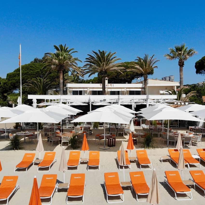 orange beach loungers parasols restaurant palm trees
