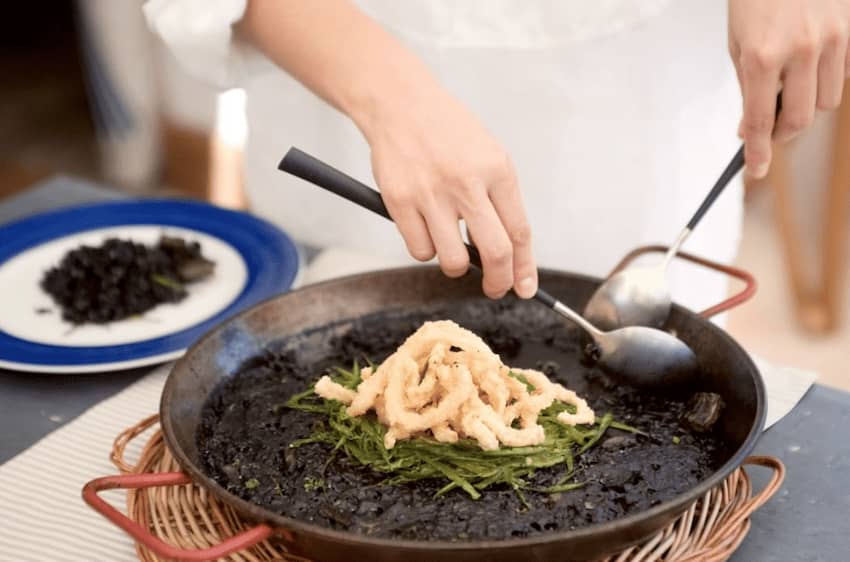 chef prepared squid ink paella calamares